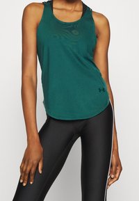 Sportowy top w kolorze morskim z okrągłym dekoltem, dopasowanym krojem i wycięciem typu racerback. Wykonany z miękkiego materiału, z subtelną fakturą i detalem w postaci logo.