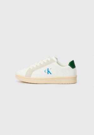 Baskets blanches avec une finition en cuir lisse, accents beiges, languette de talon verte et logo "ck" bleu ; bout rond et semelle en caoutchouc plate.