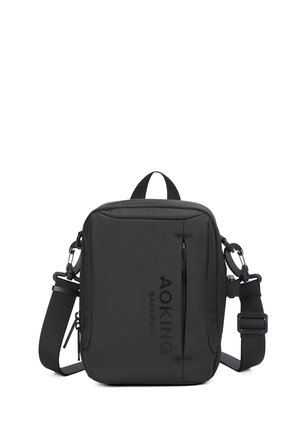 Borsa a tracolla nera realizzata in tessuto resistente, dotata di una tasca anteriore con zip, tracolla regolabile e scritta del marchio sul fronte.