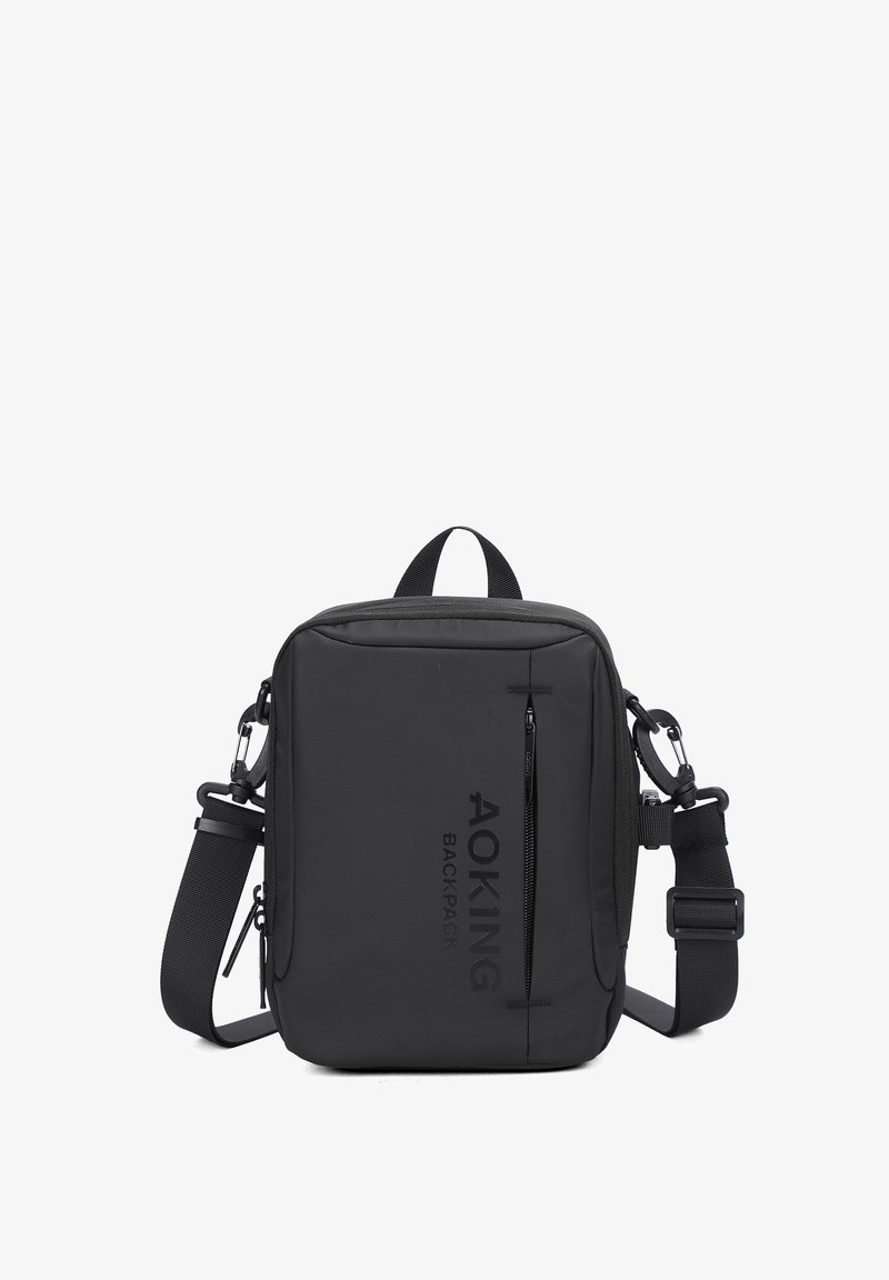 Borsa a tracolla nera realizzata in tessuto resistente, dotata di una tasca anteriore con zip, tracolla regolabile e scritta del marchio sul fronte.