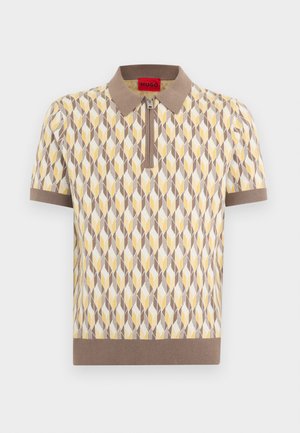 Kratka pletena polo majica s kratkimi rokavi in bež ovratnikom, z zadrgo spredaj ter geometrijskim vzorcem v bež, beli in rumeni barvi.