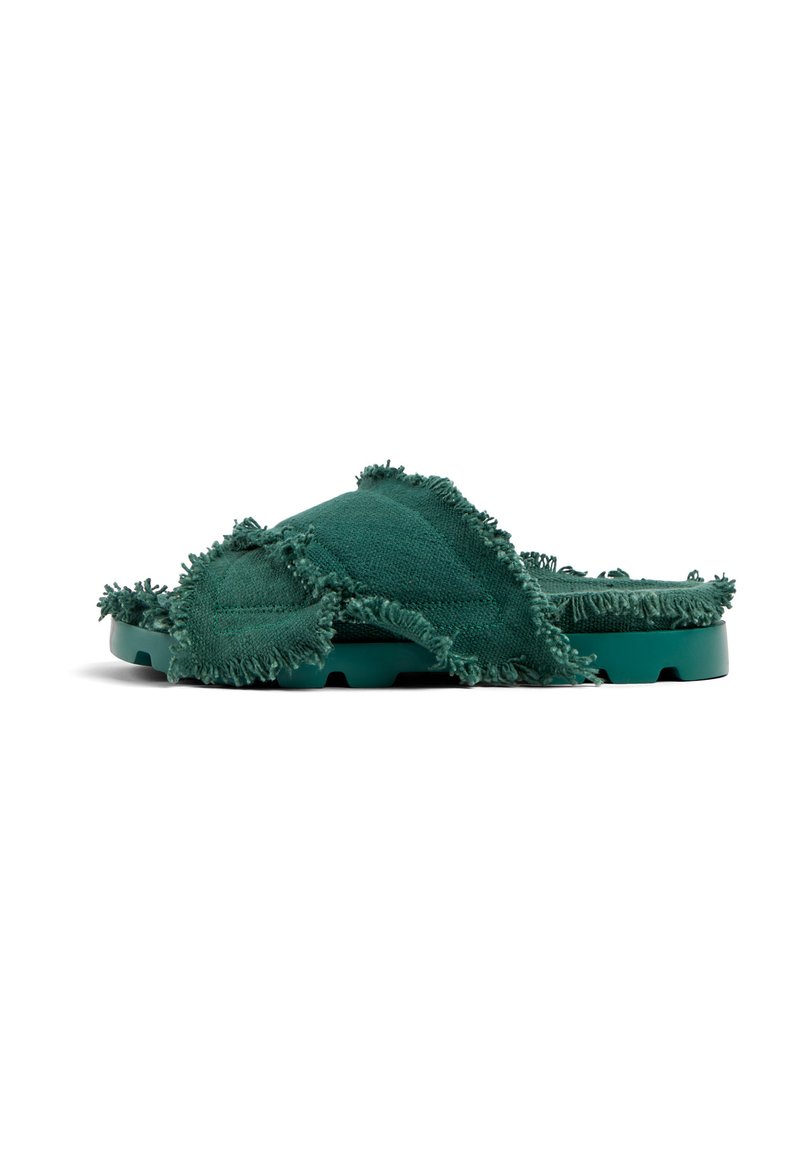 Gröna tygslippers med fransade kanter, vadderad sula och texturerad överdel. Lätt konstruktion med öppen tå.