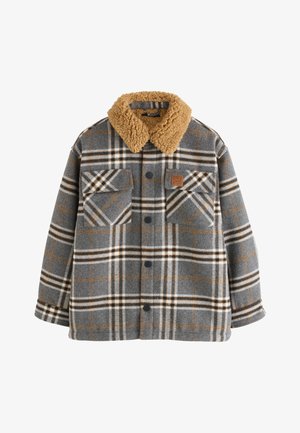 Szürke és barna kockás dzseki nagy első zsebekkel, fekete gombokkal és vastag, bézs színű sherpa gallérral.