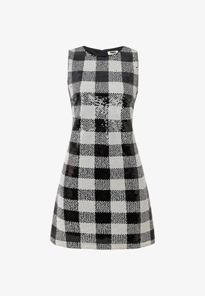Robe noire et blanche sans manches avec un motif à carreaux en sequins, encolure ronde et fermeture éclair arrière dissimulée. Silhouette trapèze.