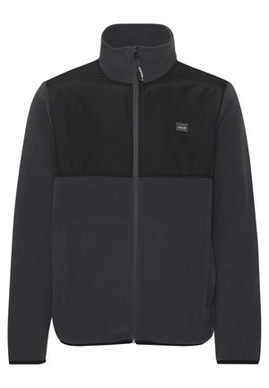 Chaqueta de forro polar gris con panel superior negro. Presenta un cuello alto, cremallera frontal y bolsillos con cremallera. Diseño sencillo, textura suave y ajuste moderno.