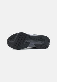 Suela de zapatilla negra con goma estampada para agarre, logotipo en relieve y elementos de diseño texturizados para tracción y durabilidad.