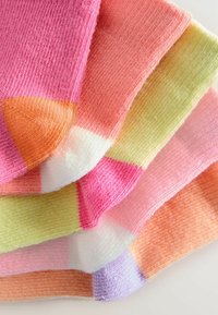 Colorful socks in pastel hues of pink, orange, yellow, and green, featuring a gradient design with contrasting toe and heel accents.