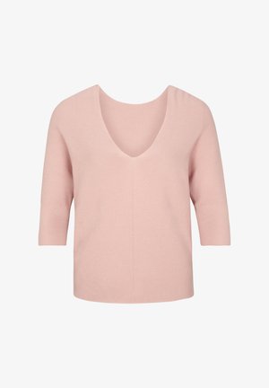 Zwarte skinny jeans gecombineerd met een geribbelde roze top en een oversized zwarte blazer; blush enkellaarsjes met een blokhak maken de outfit af.