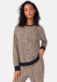 Sudadera con estampado de leopardo en beige y negro. Mangas largas, cuello redondo con ribete negro acanalado y puños acanalados en el dobladillo. Textura suave.