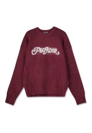 Burgundy sweater with ribbed cuffs and hem, featuring a fluffy white logo "PEGADOR" across the chest. Soft texture and relaxed fit.