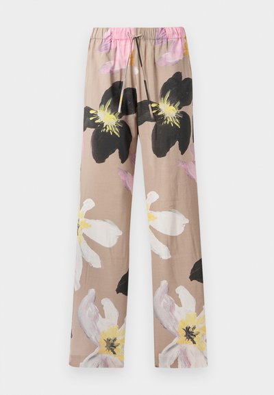 Pantaloni a stampa floreale in beige con grandi fiori bianchi e neri, dotati di un elastico in vita e un laccetto rosa.