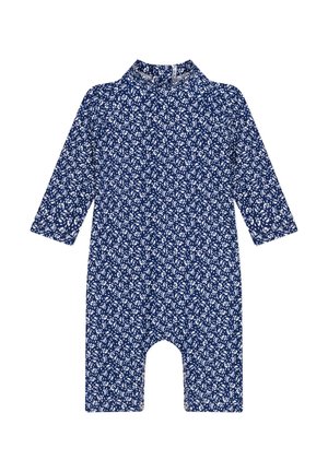 Combinaison à manches longues en tissu bleu marine avec un motif floral blanc, dotée d'un col et de jambes ouvertes pour faciliter les mouvements.