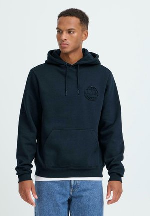 Navy hoodie made from soft fabric, featuring a kangaroo pocket and a textured round logo on the chest. Adjustable drawstring hood.