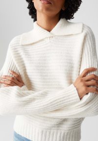 Maglione bianco a coste con colletto ripiegato e maniche lunghe, caratterizzato da una texture morbida e sottili righe orizzontali.