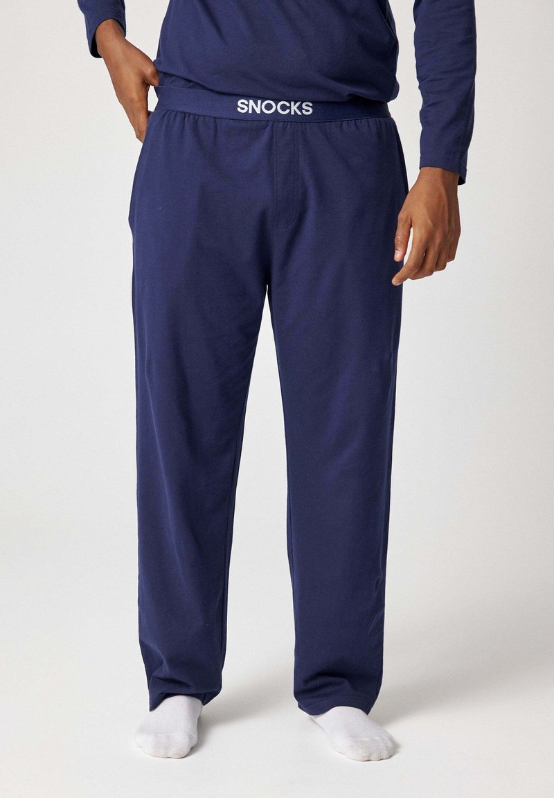 Marineblauwe katoenen pyjamabroek met een elastische tailleband voorzien van witte "SNOCKS" branding, losse pasvorm en zachte textuur.