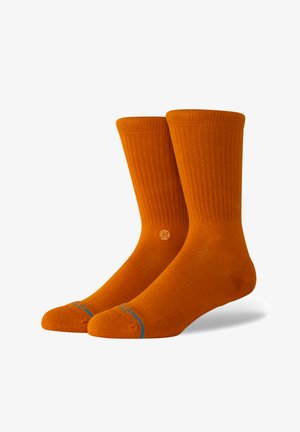 Orange cotton crew socks with ribbed texture, logo detail on the side, and contrasting blue accent at the toe. Smooth finish.