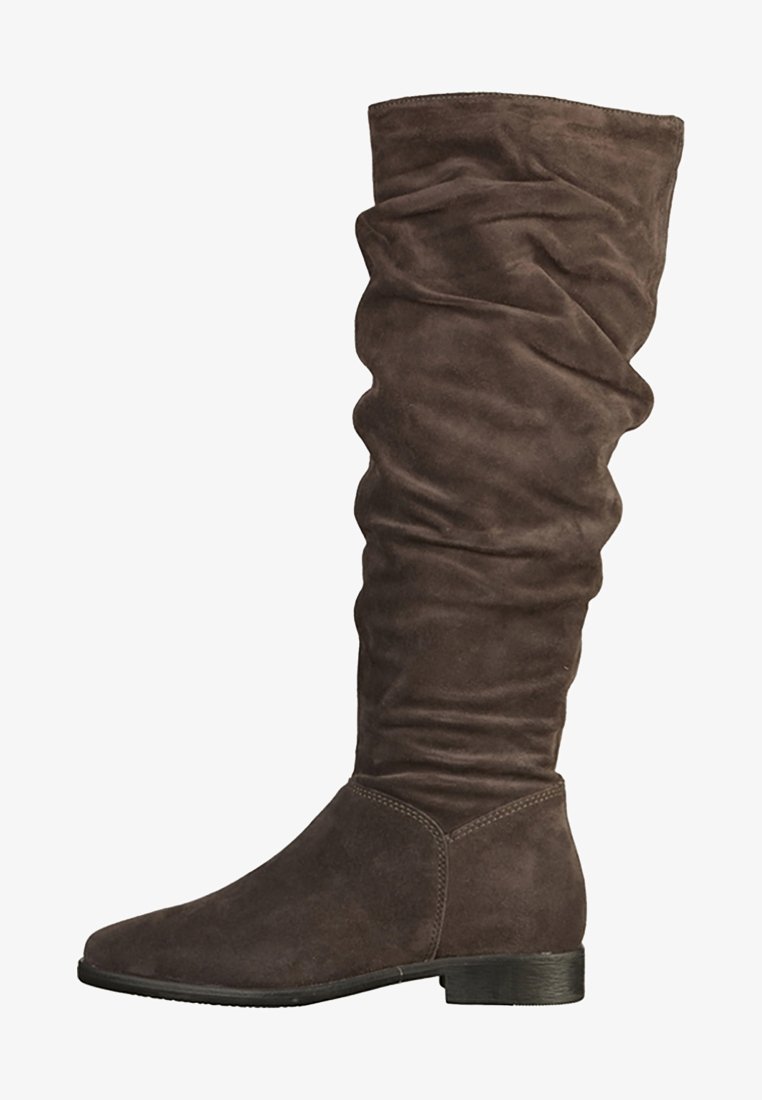 Botte montante en daim marron avec tige souple, talon bas empilé et bout arrondi, conçue pour un usage décontracté ou habillé.