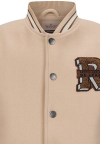 Beige Wollmischjacke mit geripptem Kragen, der braune und cremefarbene Streifen aufweist, metallischen Druckknöpfen und einem gestickten "R"-Patch.