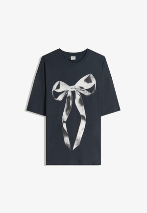 Tricou din bumbac de culoare bleumarin închis, cu un grafic mare în formă de fundiță argintie din satin în centru, având mâneci ample și guler rotund.