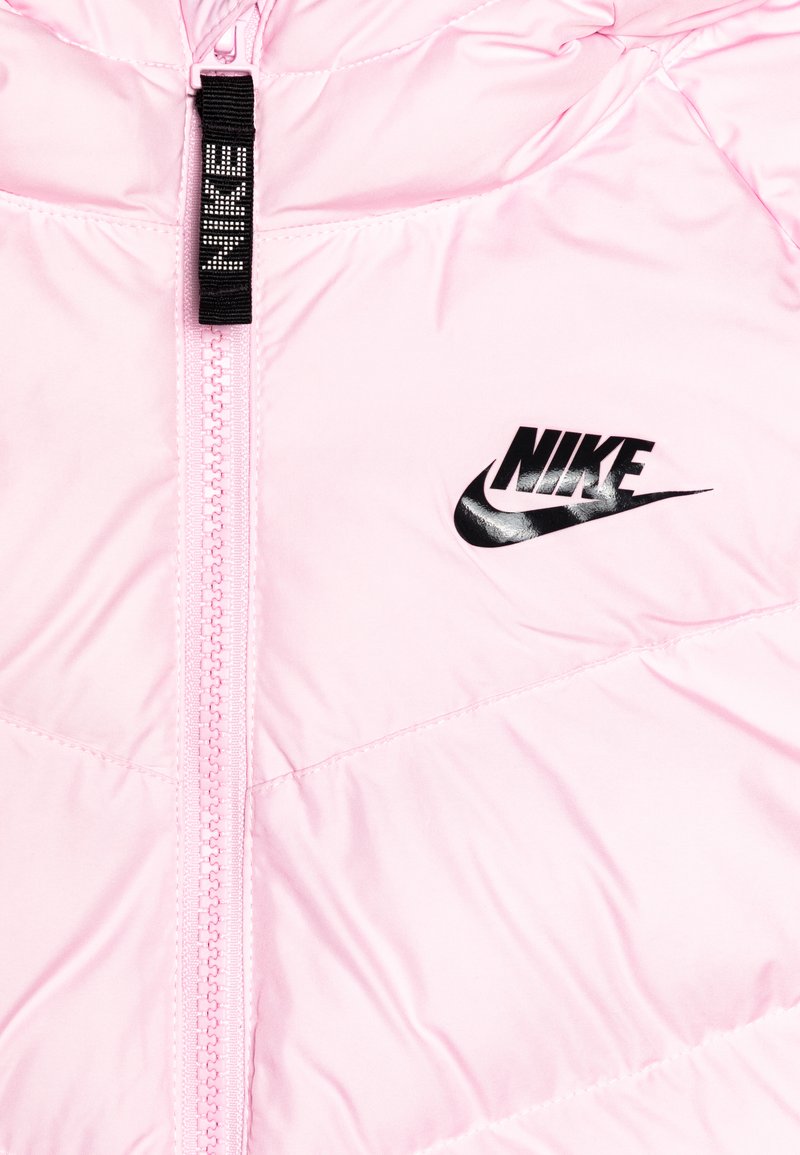 Różowa kurtka puchowa Nike z zamkiem błyskawicznym z przodu, z czarnym logo i gładką, błyszczącą fakturą. Lekka, z przeszytymi panelami.