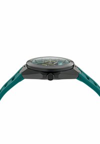 Reloj deportivo con caja negra, correa de goma color teal y esfera texturizada con acentos verdes y elementos luminosos. Botón de presión en el lateral.