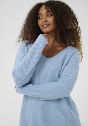 Maglione azzurro chiaro in maglia costina con scollo a V e maniche lunghe. Tessuto morbido, vestibilità ampia e design leggermente oversize.