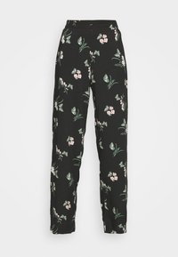Pantalon noir taille haute avec jambes fuselées, présentant un imprimé floral de fleurs rose clair et de feuilles vertes dispersées un peu partout.