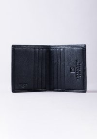 Black leather wallet with six card slots, textured exterior, and embossed logo. Opens flat with a minimalist design and no additional compartments.