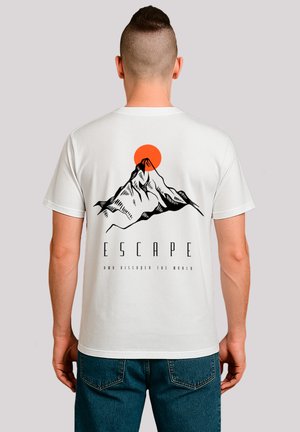 Weißes Baumwoll-T-Shirt mit einem schwarzen Berg-Graphic und einer orangefarbenen Sonne, mit dem Text "ENTFLIEHEN UND DIE WELT ENTDECKEN" darunter.