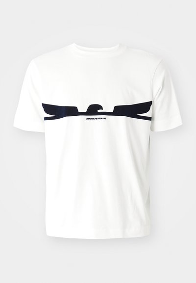 Witte katoenen t-shirt met een marineblauwe adelaar grafiek en de tekst "EMPORIO ARMANI" onder het ontwerp. Korte mouwen en een ronde hals.