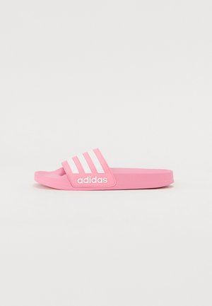 Pink Adidas slide sandal features a soft rubber design, three white stripes, and logo detail on the strap, with a flat sole.