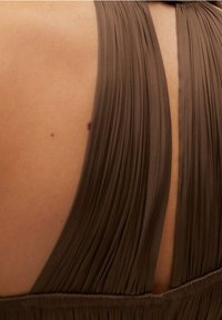 Vestido de tela marrón plisado con un profundo corte en la espalda, que presenta tirantes anchos y un detalle de superficie texturizada que le confiere un aspecto fluido.