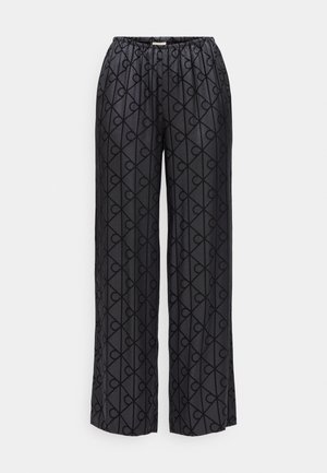 Schwarze weite Hose mit elastischem Bund, ausgestattet mit einem tonalen geometrischen Herzmuster. Aus glattem Stoff mit weicher Textur gefertigt.