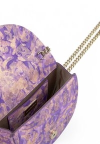 Bolso de mano morado con un patrón, con una correa de cadena dorada, cierre magnético y un bolsillo interior. Superficie texturizada con diseños intrincados.