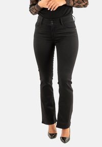 Jeans de mezclilla elásticos negros con corte recto, dos bolsillos frontales y cierre de botón. Textura suave con hardware mínimo.