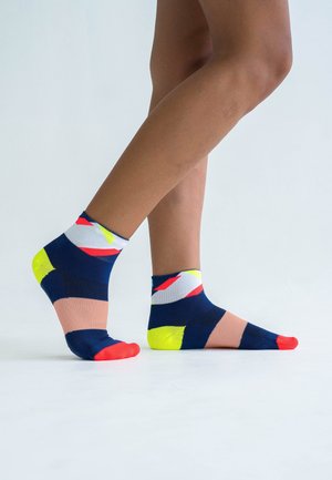 Navy blue ankle socks featuring geometric patterns in bright colors, including yellow, red, and white, with a textured knit design.