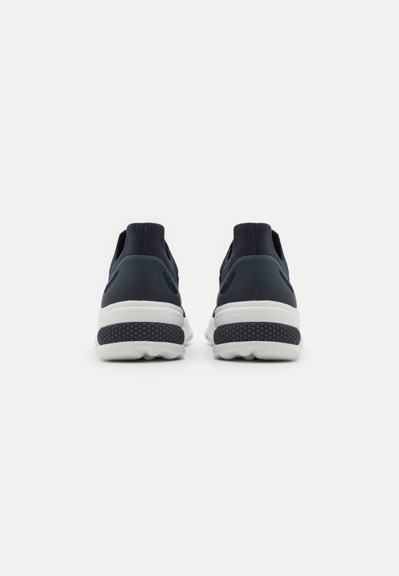 Sneakers slip-on blu Navy con parte superiore in maglia testurizzata e suole in gomma bianca. Presentano un tallone imbottito e un design a punta rotonda.