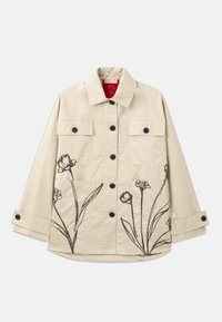 Giacca in cotone beige con ricami floreali neri sul lato sinistro inferiore. Presenta una chiusura frontale con bottoni e due tasche sul petto.