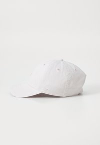 Lys pink bomulds hat med en buet skygge, ventilationshuller på siden og diskret broderet detaljer foran og bagpå.