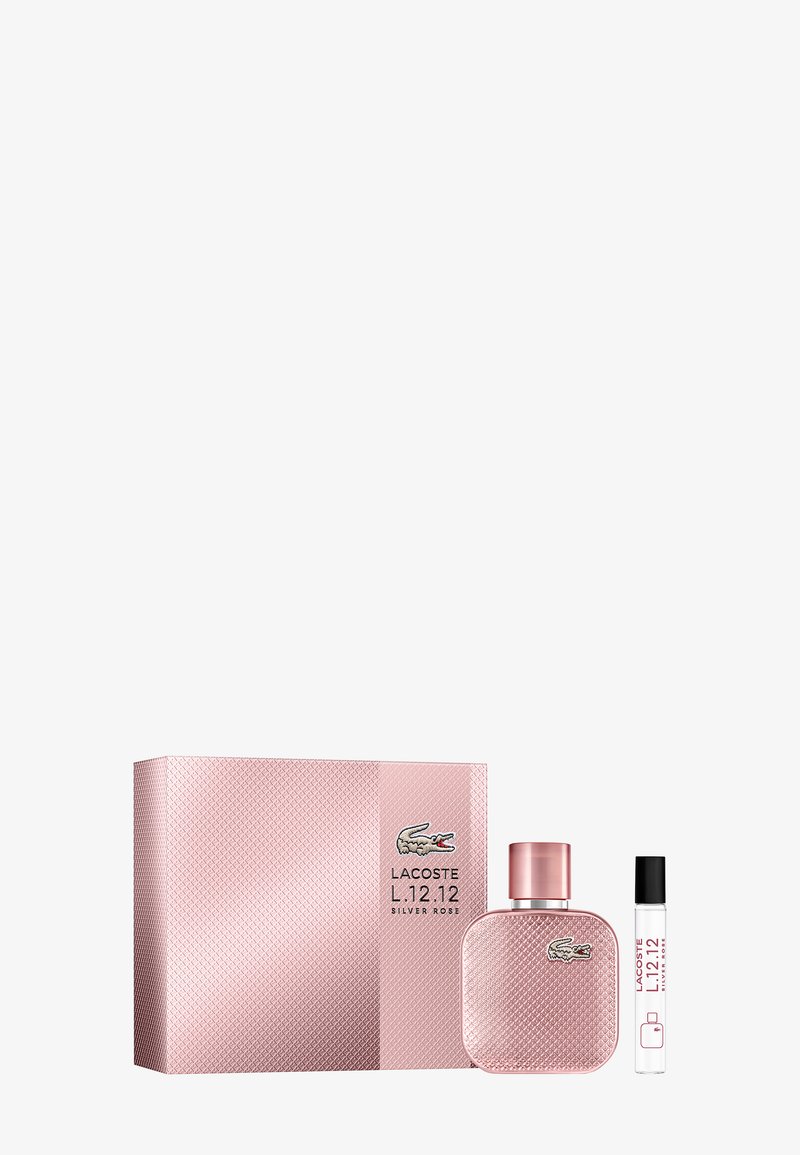 Coffret parfum Lacoste L.12.12 Silver Rose avec boîte texturée rose, flacon rose assorti et un petit vaporisateur transparent avec bouchon noir.
