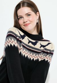 Schwarzer gestrickter Pullover mit einem cremefarbenen Muster an der Schulterpartie, das rote und marineblaue Akzente aufweist, mit kleinen Tier-Silhouetten und geometrischen Designs.