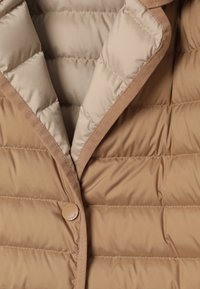 Veste matelassée marron avec une texture lisse et brillante, un col à revers et une fermeture à un seul bouton, avec un matelassage horizontal.
