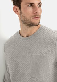Szary, pikowany sweatshirt z okrągłym dekoltem, z teksturowanym wzorem w diamenty i małą kieszonką na lewej piersi.