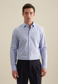 Camicia azzurra chiara, con bottoni, realizzata in un tessuto liscio, con maniche lunghe e colletto classico, caratterizzata da un taglio dritto e una finitura ordinata.