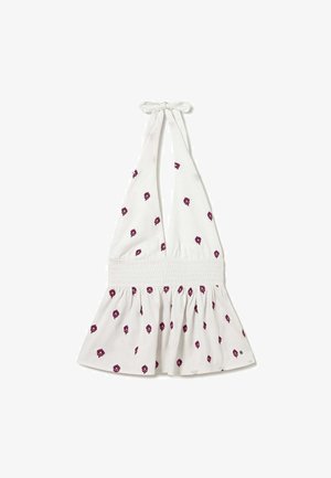 Haut blanc à col licou avec taille smockée et petits imprimés floraux violets dispersés sur le tissu.