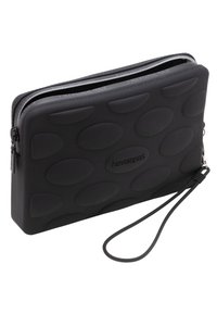 Pouch in gomma nera con texture ovale, chiusura a zip e tracolla. Presenta un marchio in rilievo sulla parte anteriore. Design slim e rettangolare.