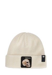 Romige gebreide beanie met ribbelstructuur, voorzien van een zwarte patch met een doodskop en het woord "CANCELLED". Met een omgeslagen rand.
