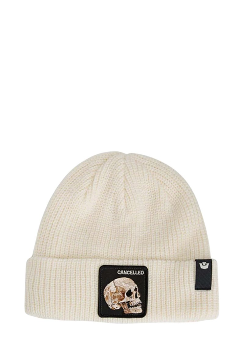 Romige gebreide beanie met ribbelstructuur, voorzien van een zwarte patch met een doodskop en het woord "CANCELLED". Met een omgeslagen rand.
