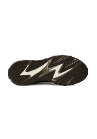 Suela de zapatilla deportiva negra con un patrón de adherencia en zigzag, que presenta acentos blancos en contraste y un acabado texturizado para mejorar el agarre.