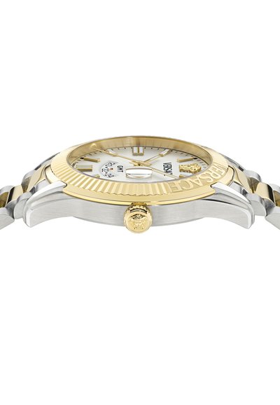 Reloj de acero inoxidable en oro y plata con una esfera blanca, acentos dorados, bisel texturizado y una corona con un emblema de león.